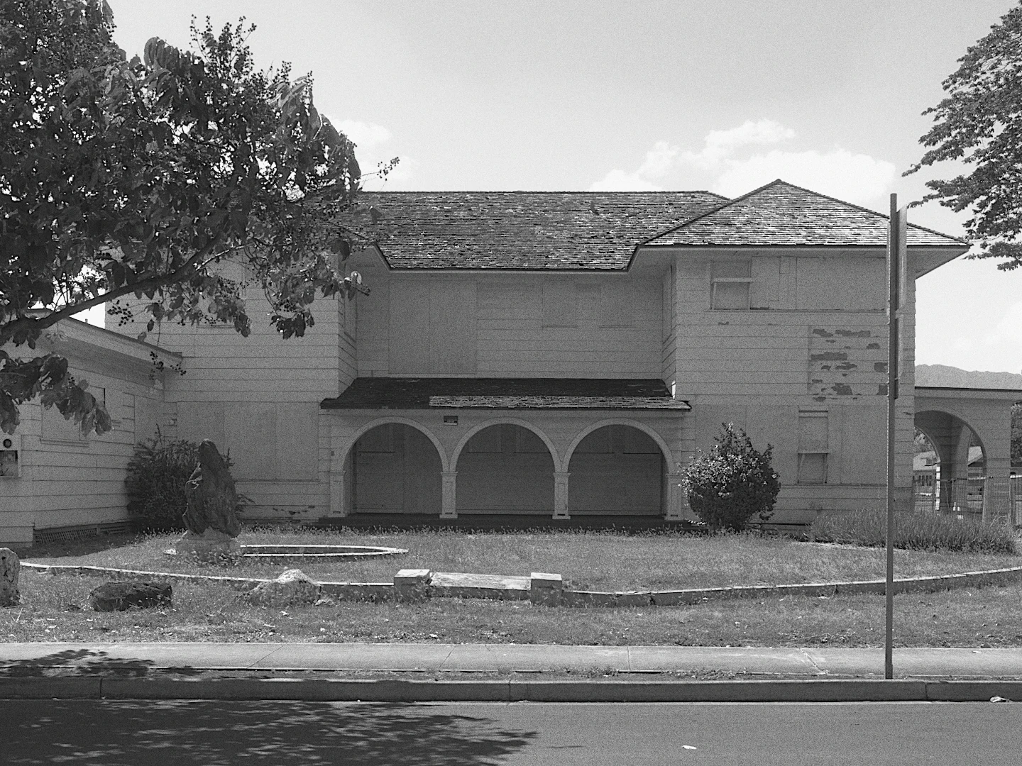 A white two storey house with arches, in black and white with Ilford FP4 Plus 125.